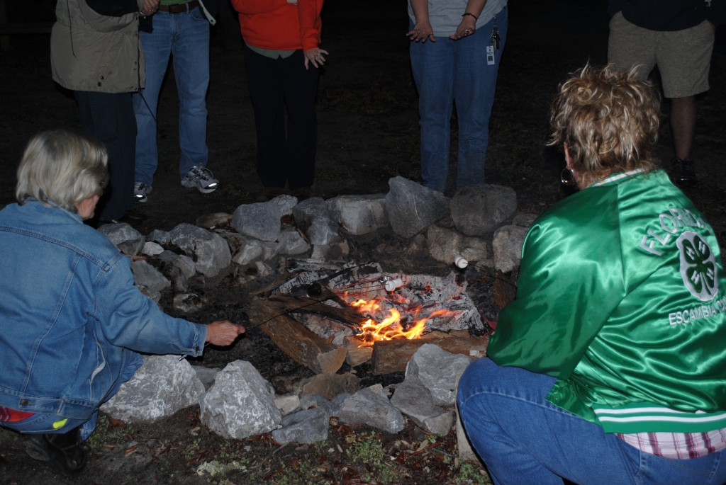 4-H Volunteers cook s'mores over the campfire at Camp Timpoochee