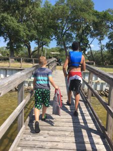 A camp counselor walking with his camper on a dock, at 4-H camp.