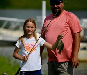 photo of a girl with a fishing pole and fish