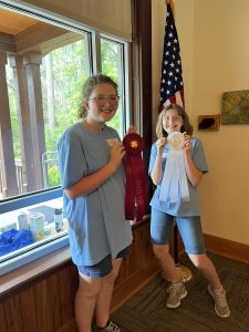 Photo of two youth with second place (red) and third place (white) ribbons for wins in the independent, intermediate division at the 2025 Florida 4-H Forest Ecology Contest.