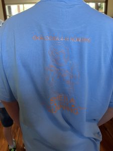 Outline image of Sheila Dunning holding an alligator on back of t-shirt. Shirt worn by youth participating in her honor at the 2025 Florida 4H Forest Ecology Contest.