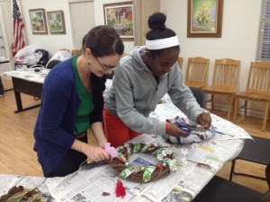 Gulf County adult 4-H Club leader assists a 4-Her on the finishing  touches of her grapevine wreath. 