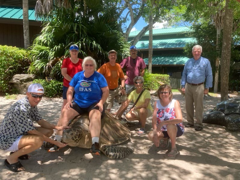participants pose with a turtle statue