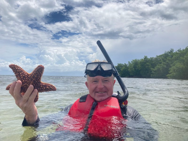 Man holding a starfish while snorkeling