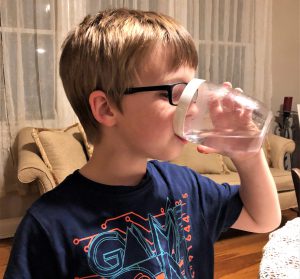 Boy drinking water from clear glass