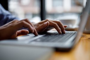 hands typing on a laptop computer