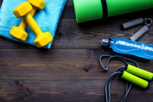 Fitness equipment on dark wooden background top view.