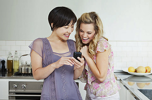 Laughing women using cell phone