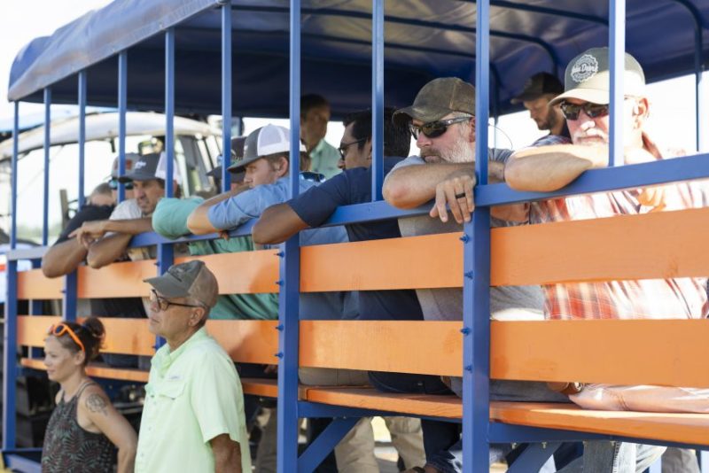 Peanut Field Day attendees on the wagon, listening to a speaker.